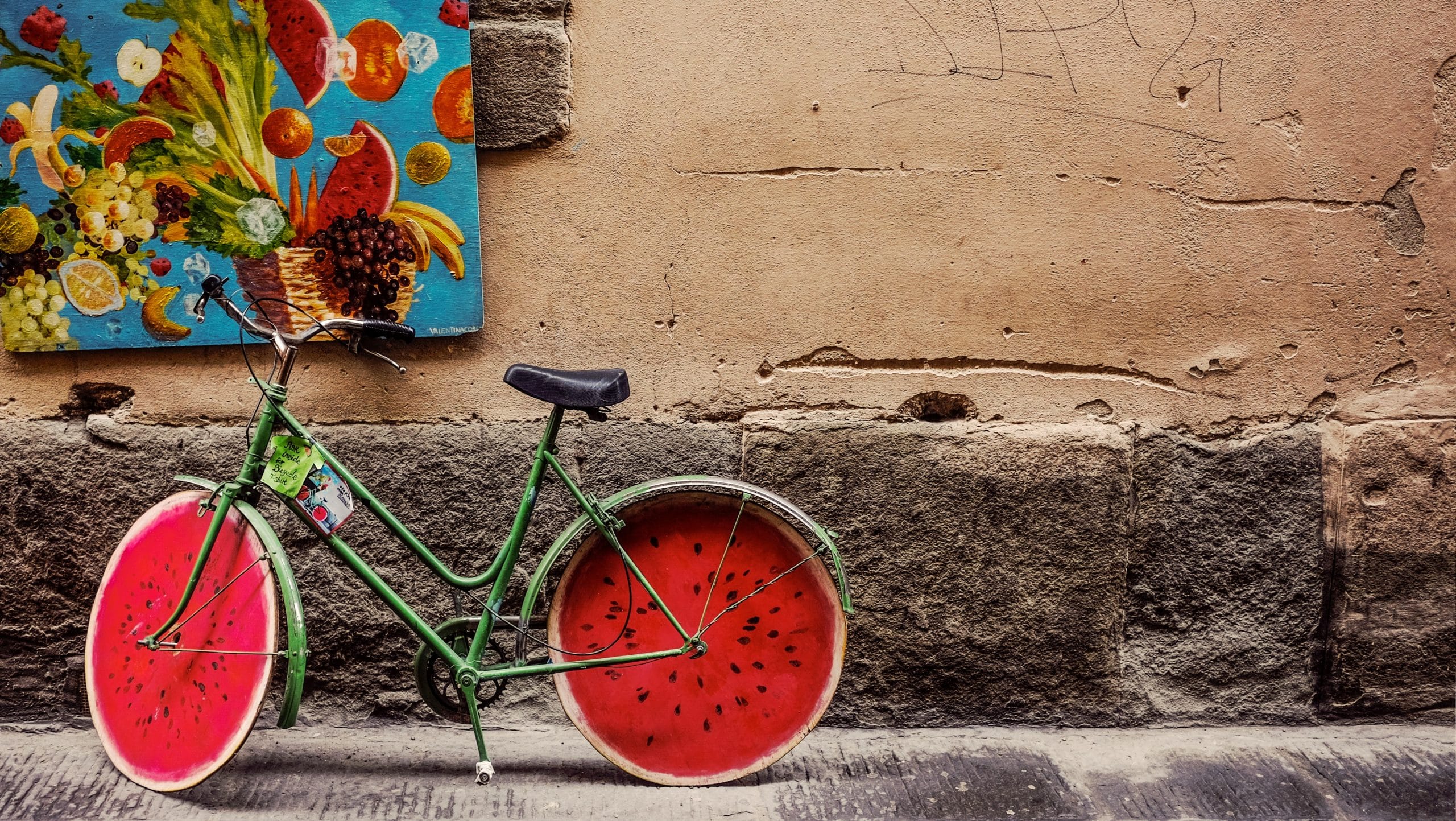 Vélo avec roues en pastèque, mur peint fruits.