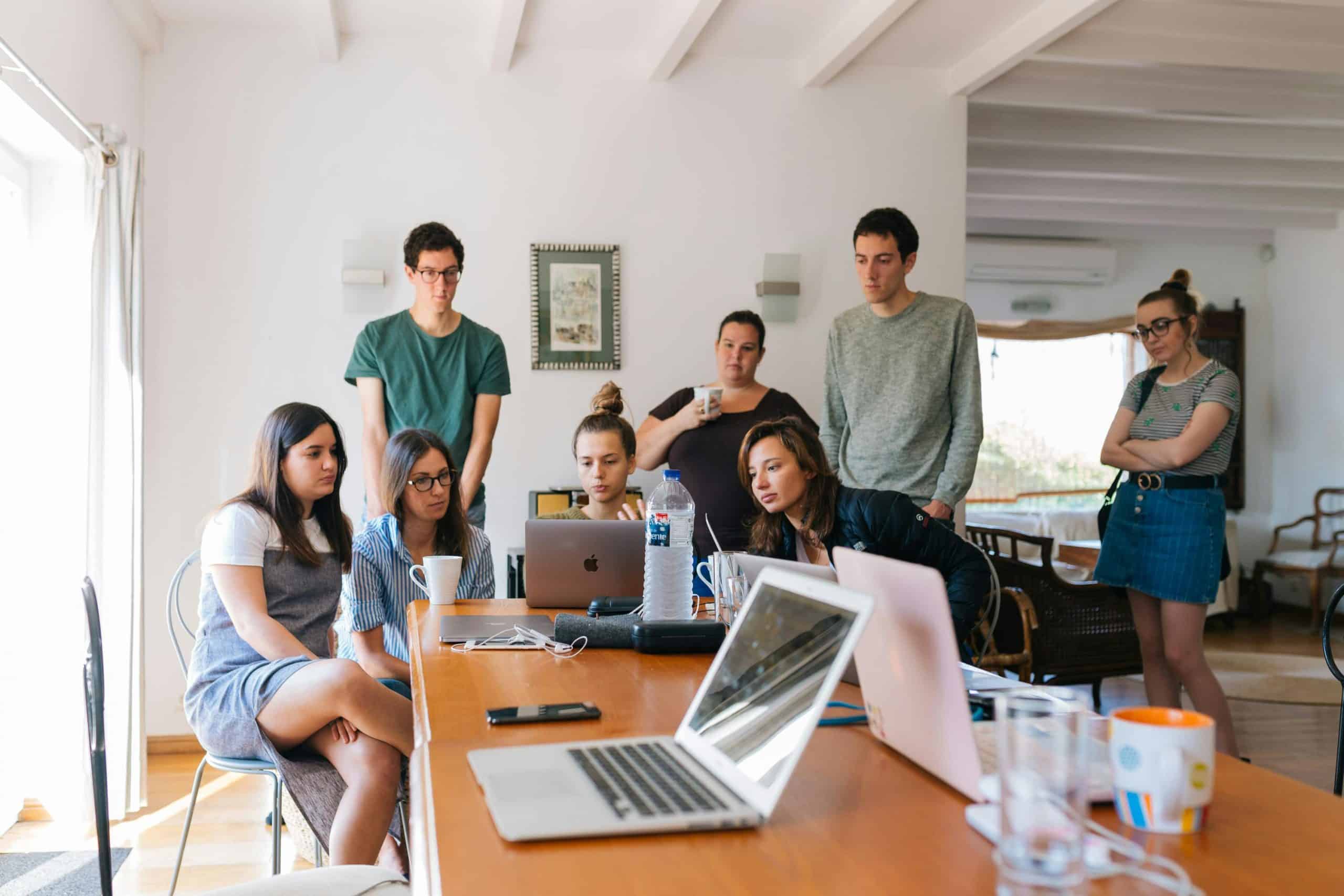 Groupe de jeunes en réunion avec ordinateurs.